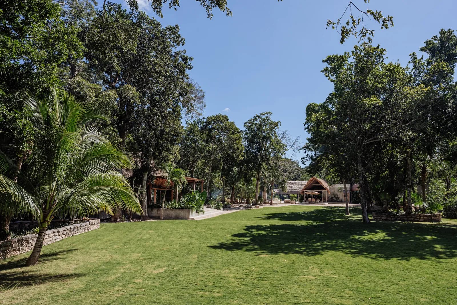 Onze Xpuha, open jungle lawn between palapas